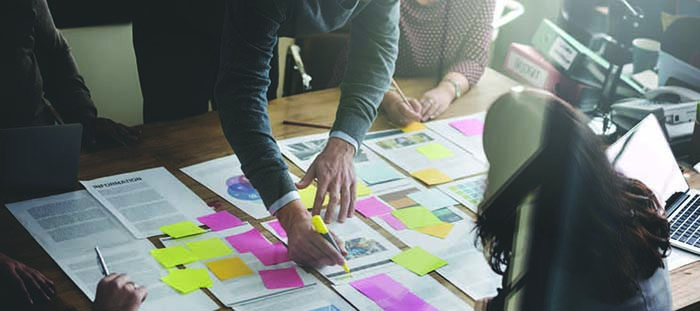 Image of people point to content on table Image of people point to content on table