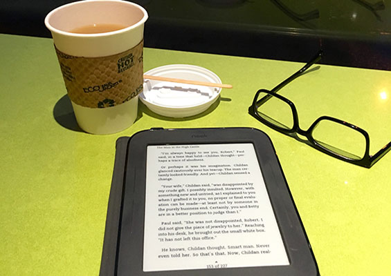 A person reads on an eReader in a coffee shop