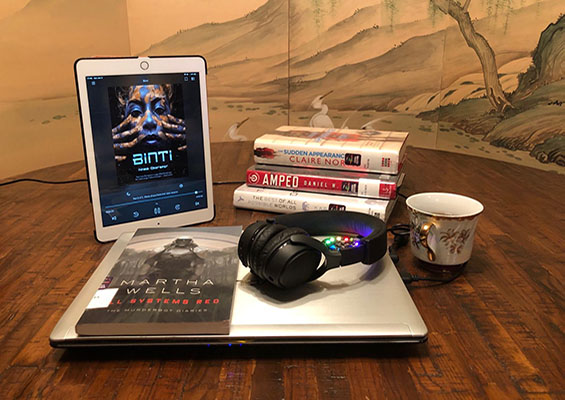A tablet showing the eBook Binti with a stack of the other books listed in this article.