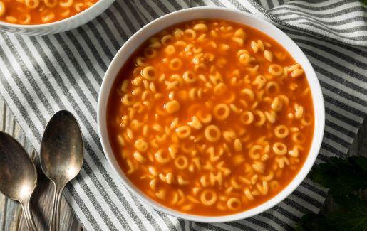 A photo of alphabet Soup on a striped placemat.