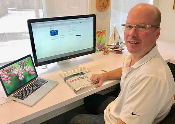 Jim Hamilton sits at his computer desk with his CompTIA Security+ study guide