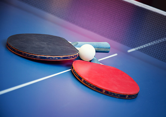 Cybersecurity red team or blue team Red and blue ping pong paddles on a ping pong table