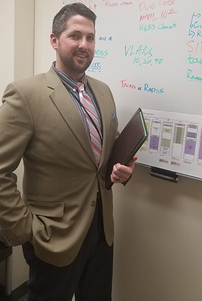 David Kent stands in front of a whiteboard in one of the classes he teaches