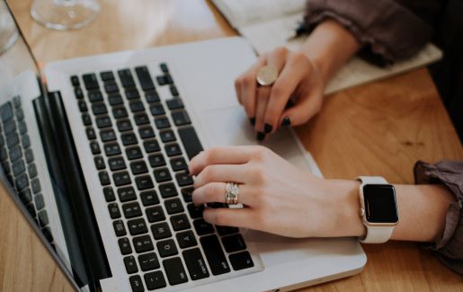 Differences between security+ 501 and 601 Woman typing on laptop while sitting at a wooden table.