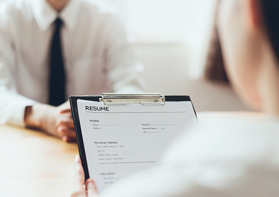 A woman looks at a man's resume during a job interview