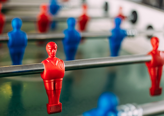 A photo of a foosball table with red and blue players