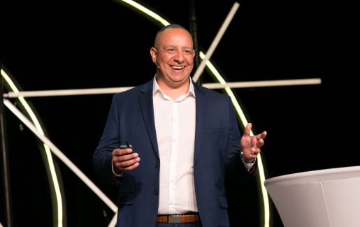 Man standing on stage giving a speech.