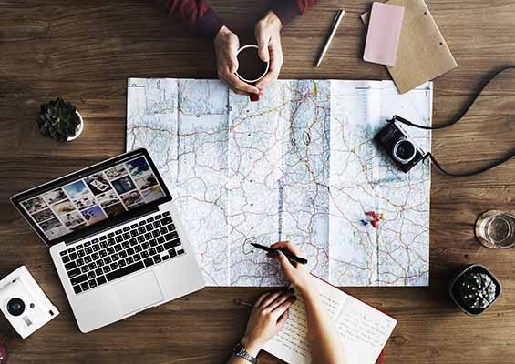 A road map spread out on a table with people taking notes and making plans.