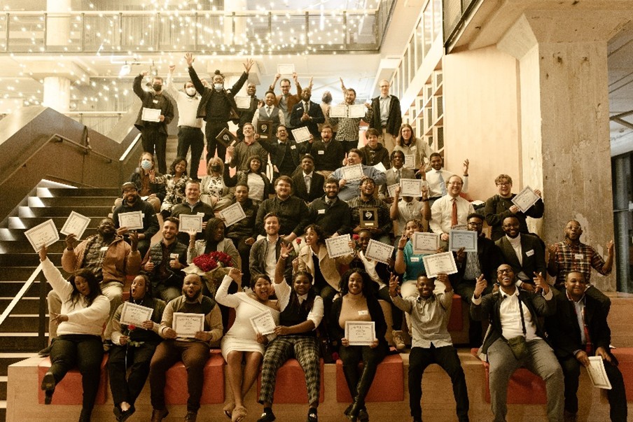 A group of people sitting on stairs holding certifications