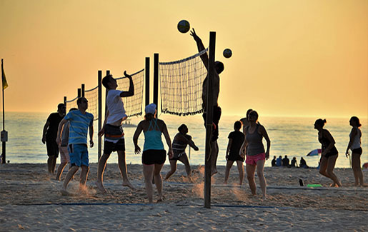 People play beach volleyball at sunset on the beach in Tampa