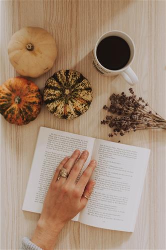 Woman's hand on book with coffee