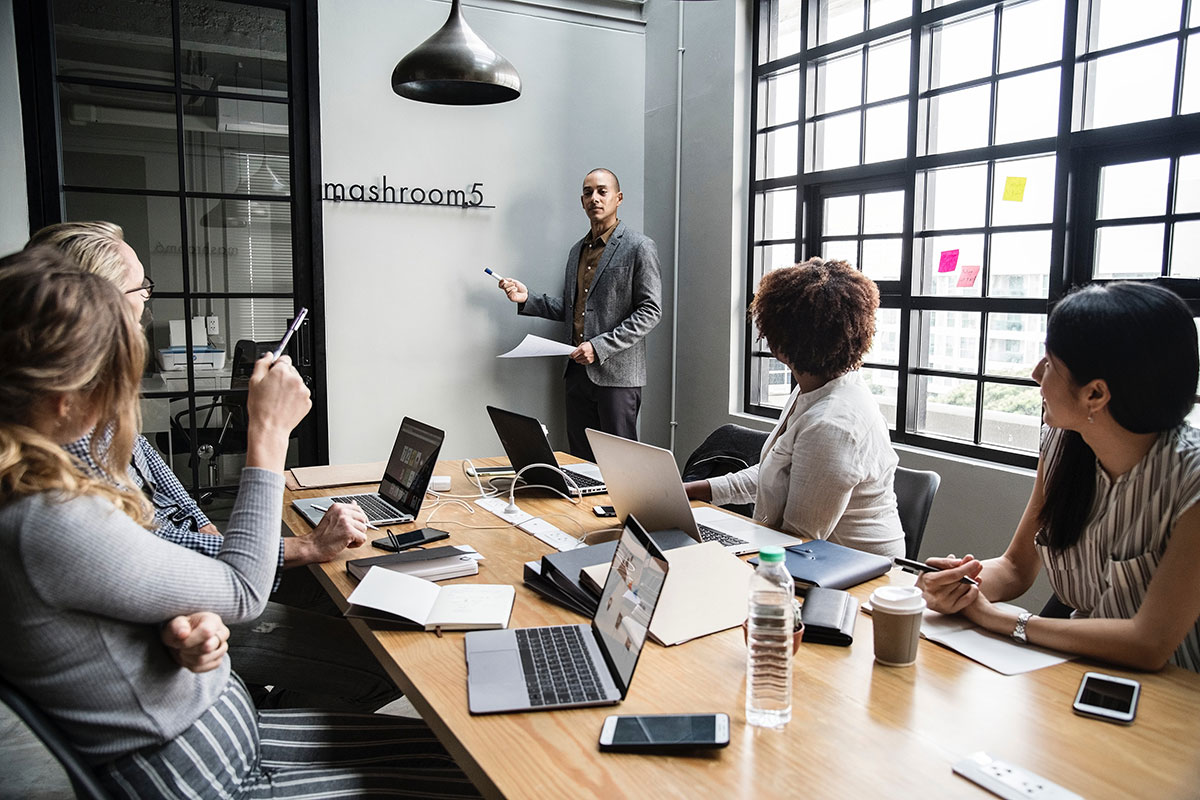 Quatre personnes lors d'une présentation de réunion de travail.