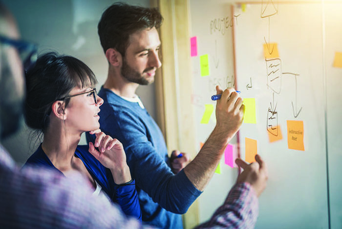 People writing on a white board