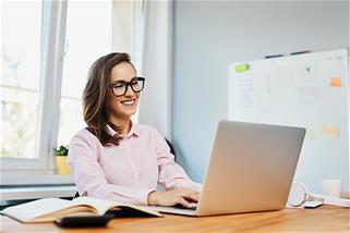 A woman works on a laptop thanks to an operating system