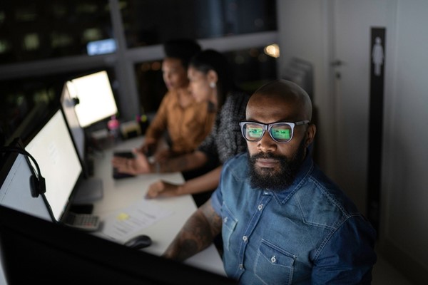 Male wearing glasses working on his desktop computer